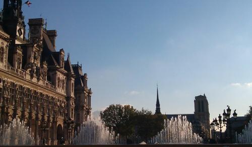 Soleil couchant avec Notre Dame et pyramides d'eau devant la mairie.