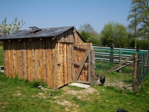 Ma cabane à St Aubin, est blottie au fond du jardin, on y voit des poules sur le seuil